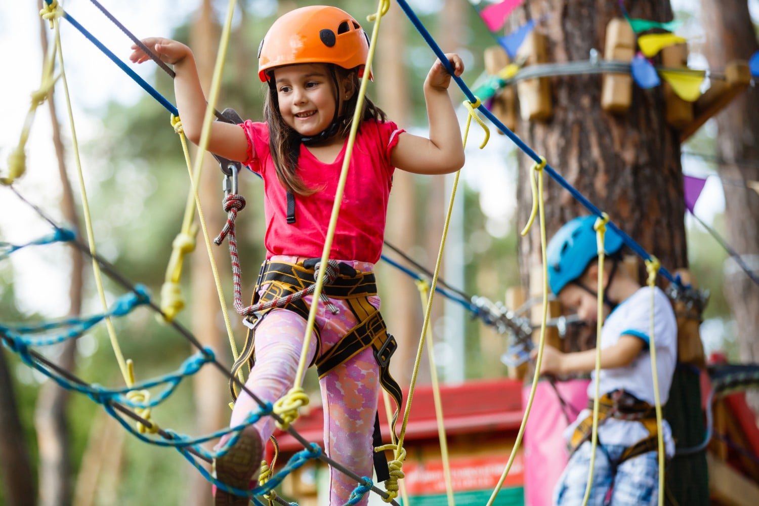 Little girl climbs on ropes course