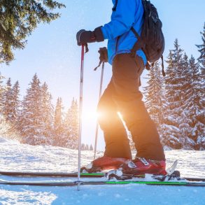 Closeup of ski and shoes of skier on a trail in the forest
