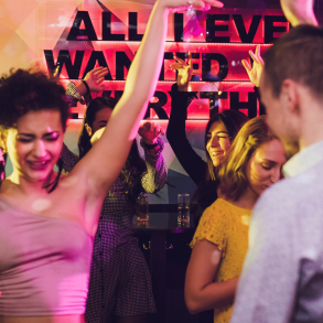 Group of people dancing inside of a club at night