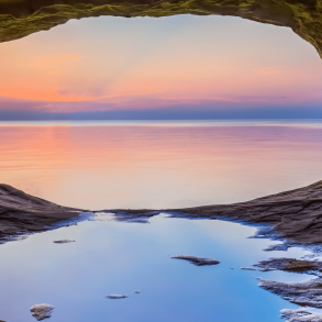 Underneath of a natural bridge in front of a fading sunset
