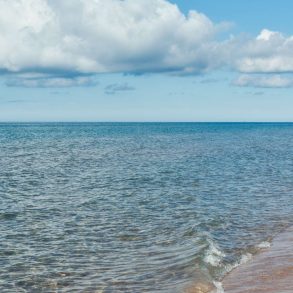 A beach in Western Michigan with a few clouds on the horizon.