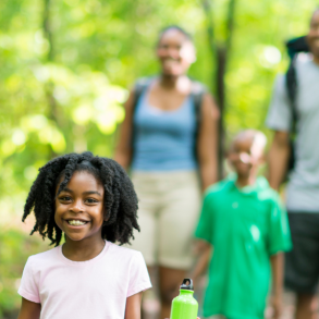 family hiking in green woods