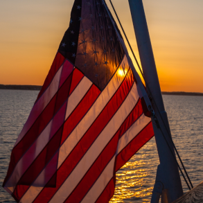 usa flag over water at sunset