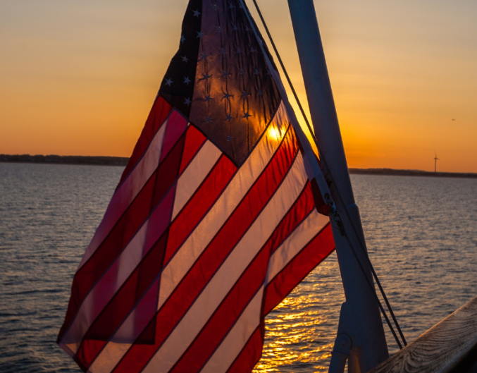 usa flag over water at sunset