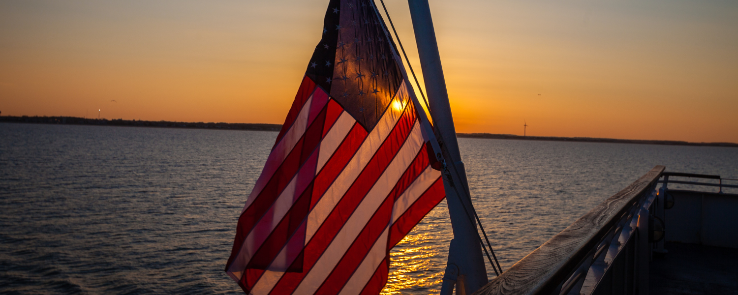 usa flag over water at sunset