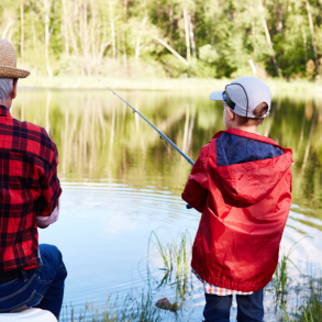 man and boy fishing beside a lake