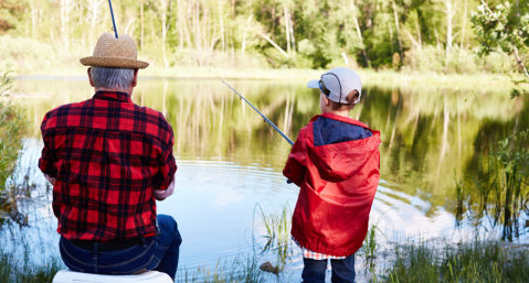 man and boy fishing beside a lake