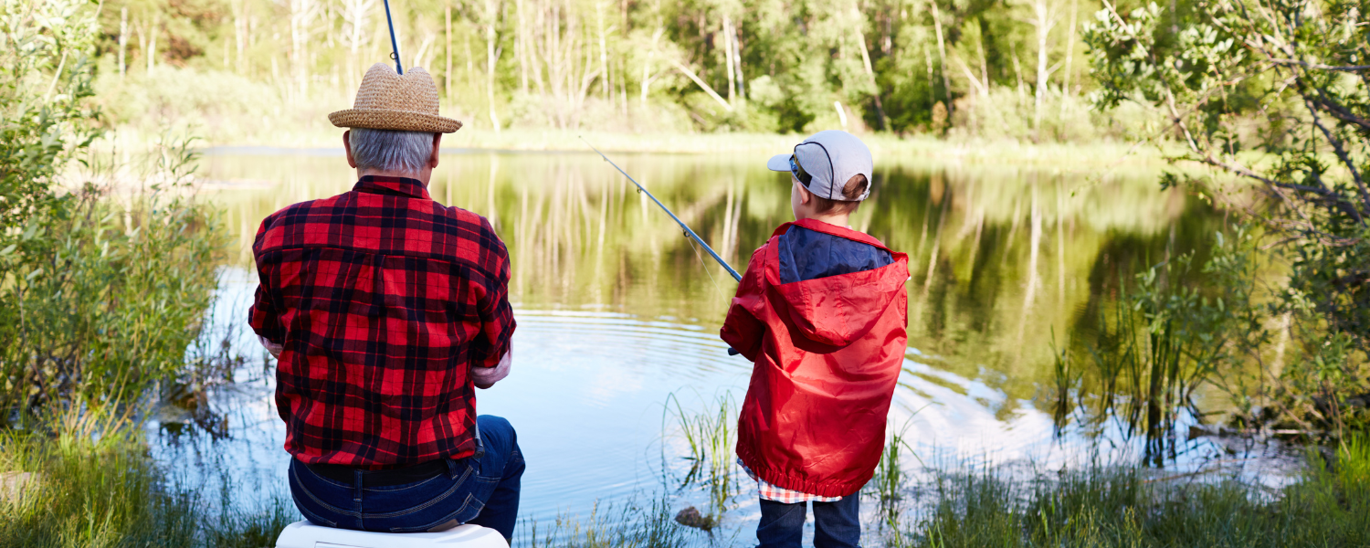 man and boy fishing beside a lake