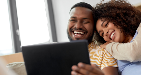 couples smiling and looking at iPad together