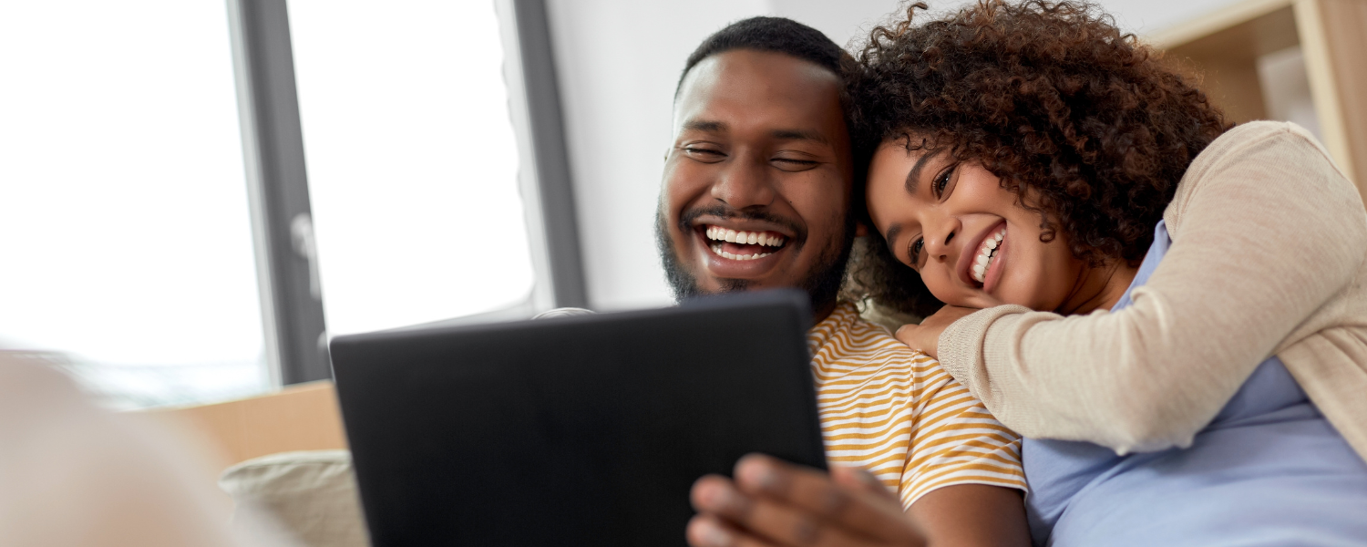 couples smiling and looking at iPad together