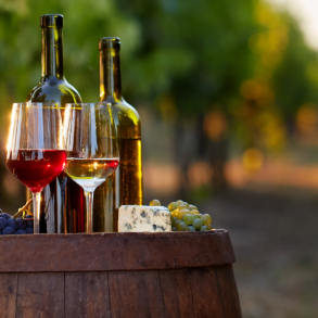 wine glasses and bottle on a barrel in a vineyard