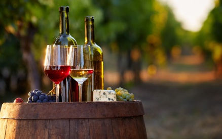 wine glasses and bottle on a barrel in a vineyard