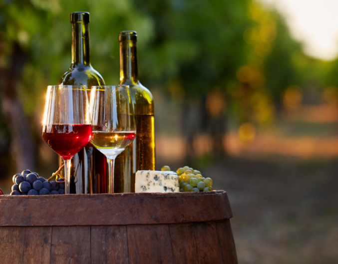 wine glasses and bottle on a barrel in a vineyard