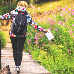 person walking across wood walkway during a hike