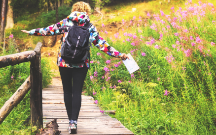 person walking across wood walkway during a hike