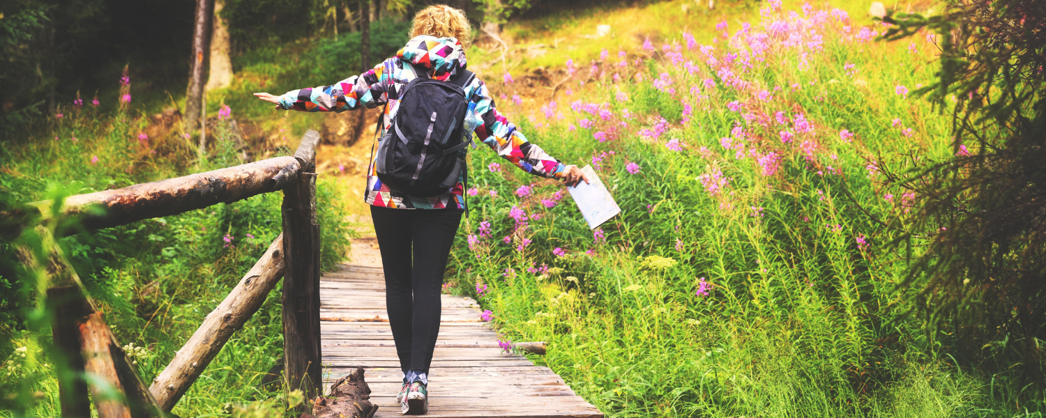 person walking across wood walkway during a hike