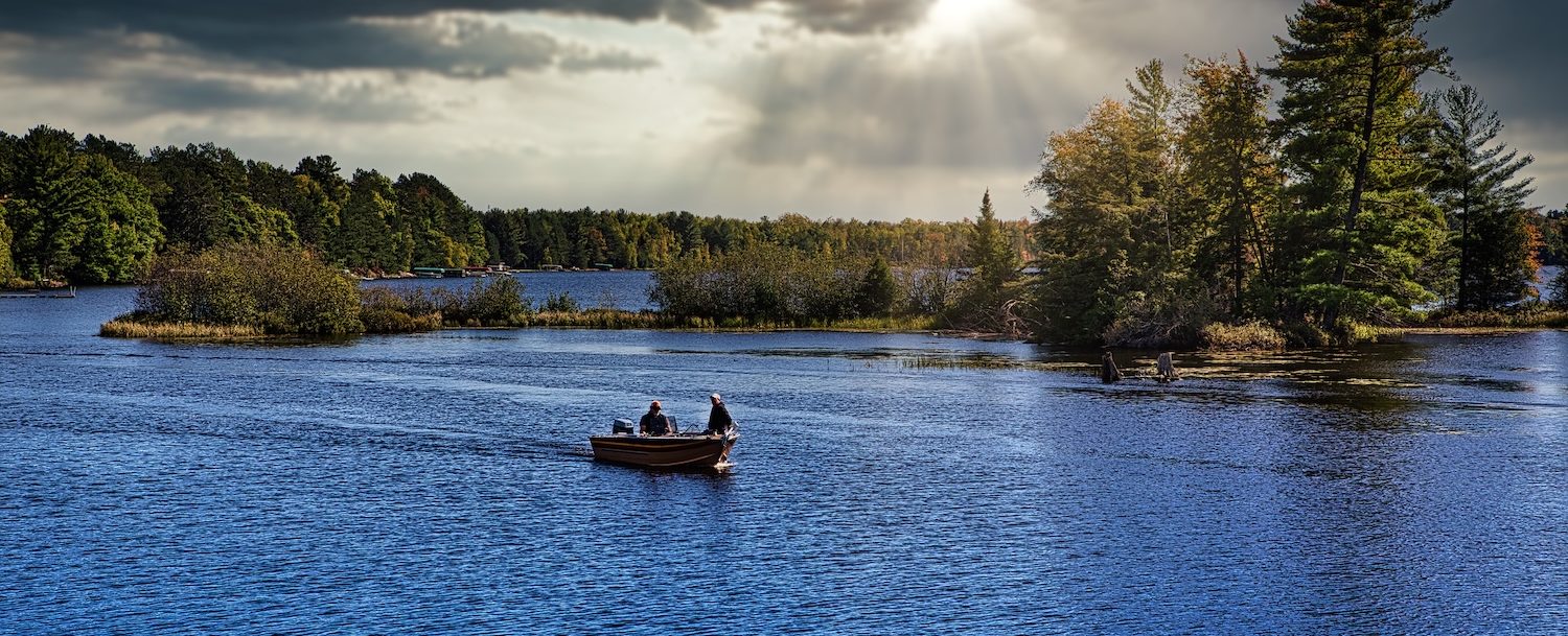 Fishermen in fishing boat on lake in Michigan.