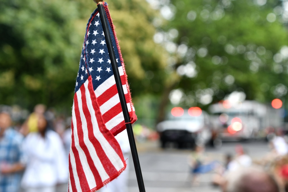 Waving an American flag at the Independence Day Parade on the 4th of July.
